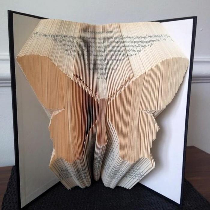 zložljiva knjiga, simetrična oblika metulja, narejena iz prepognjenih strani, znotraj odprte knjige s črno -belimi trdimi platnicami