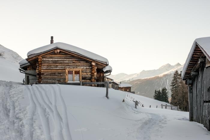 hake üzerinde ahşap evleri olan bir kış duvar kağıdı örneği, karla kaplı tepelere ve gün doğumuna doğru görünüm