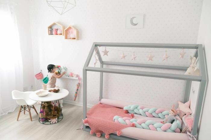 spalnica montessori, postelja montessori, postelja iz montessori koče v biserno sivi barvi, omarice na policah v obliki hiš, jaslice brez palic, ozadje v beli barvi s taupe grahom
