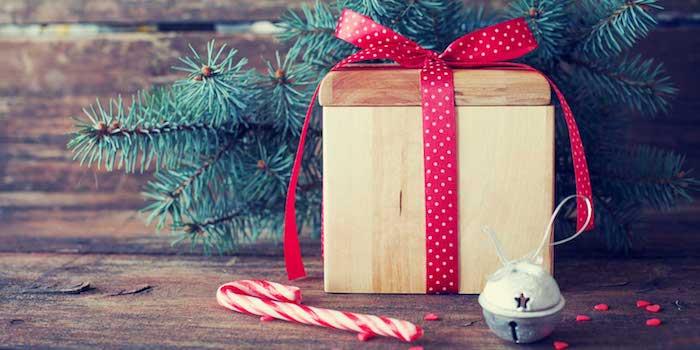 paprastas kalėdinis kalnelis, nemokamas kalėdinis atvirukas, medinė dovanų dėžutė, papuošta raudona juostele, pušies šakomis, saldainiais