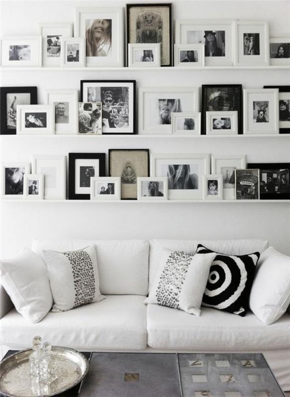çerçeveler duvarı, beyaz oturma odası, beyaz minderler, fotoğraf çerçeveleri, beyaz ve siyah fotoğraflar