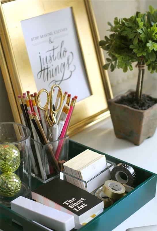 pisarniško pohištvo, majhen zeleni cvet v lončku iz terakote, zlati okvir za fotografije z navdihujočim napisom