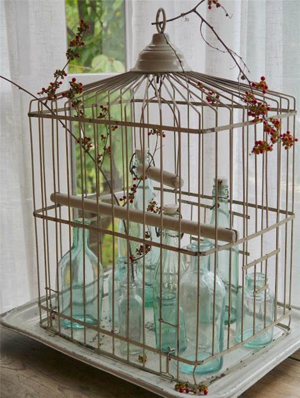 okrasne ptičje kletke, napolnjene s turkiznimi steklenicami