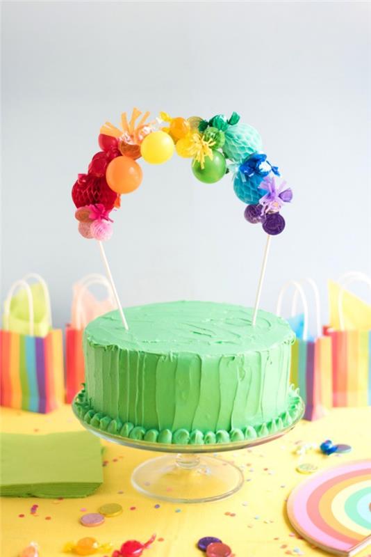 Gökkuşağı pastası nasıl süslenir, kağıt toplarla kişiselleştirilmiş bir pasta kabı ile tepesinde yeşil bir kremalı pasta