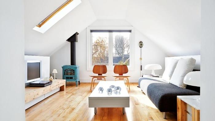 anglis pilka sofa šviesi medinė parqiet dizaino kavos staliukas medinės kėdės vintažinis židinys idėja šilta kokonuojanti svetainė po stogu