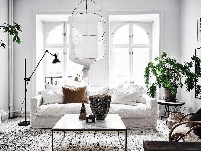 balta sofa marmuro efekto stalas baltos sienos juodai baltas berberinis kilimas šviesaus medžio parketas baltos sienos prašmatni balta pakabinama šviesa