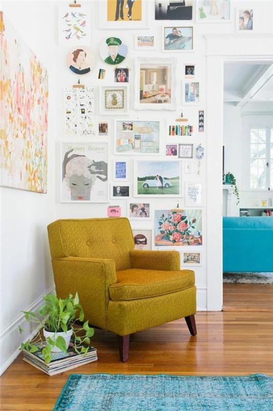 Evde bir sanat galerisi etkisi için çerçeveli duvar bölümü, hardal sarısı kanepe ve vintage turkuaz mavisi halı