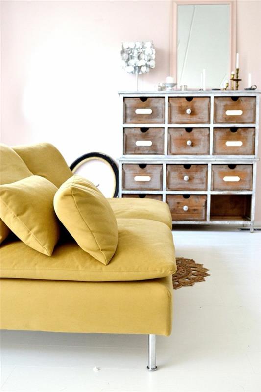 pastel pembe bir duvar ve beyaz bir zemin ile birleşen çağdaş bir tasarıma sahip sarı hardal rengi bir kanepe