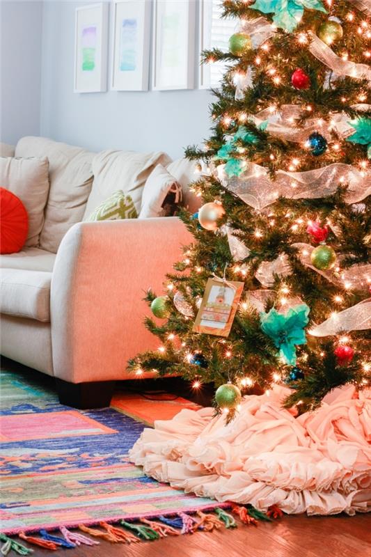 koyu ahşap parke ile beyaz duvarları olan bir oturma odasında rahat bir atmosfer, mavi ve yeşil toplarla Noel ağacı dekorasyon fikri