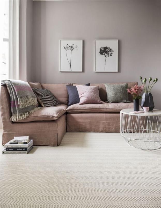 rožinė svetainė su elegantiška minkšta sofa, to paties tono kaip ir sienos, su dviem nuotraukų rėmeliais su poetiškais gėlių raštais