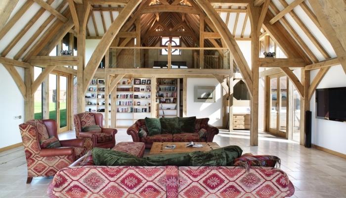 ahşap tavan ve duvarlar ile rustik tarzı çatı katı, kırmızı ve yeşil kumaş mobilyalı beyaz ve ahşap oturma odası dekoru