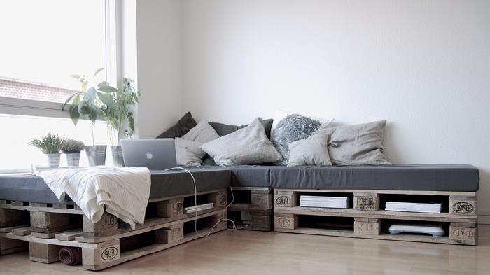 Yapması en kolay palet mobilya, depolama alanı olan bir köşe kanepe, gri şilte ve kırlentler