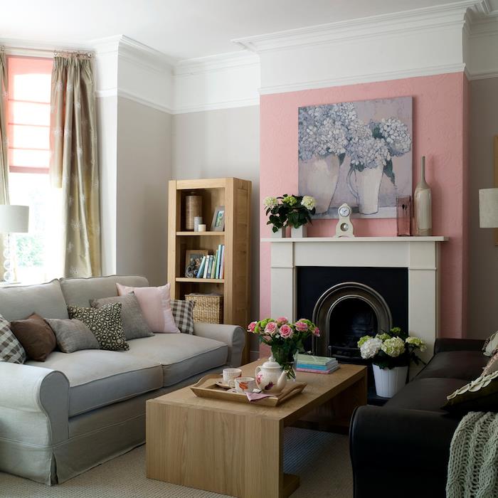 siv kavč v dnevni sobi s steno v stari rožnati barvi okoli kamina