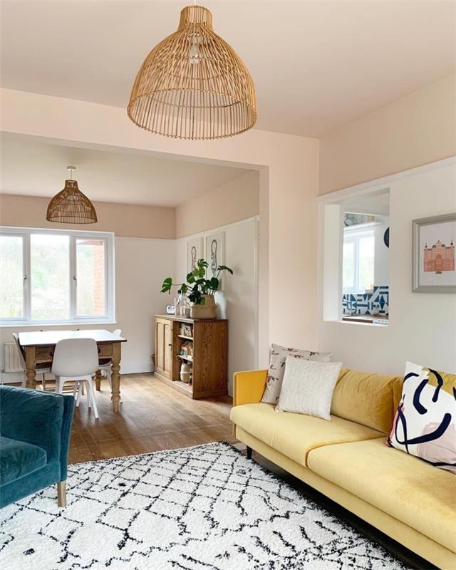 pastel pembe duvarlar ve renkli kumaş mobilyalarla döşenmiş koyu ahşap zemin ile oturma odası dekorasyon fikri 2020