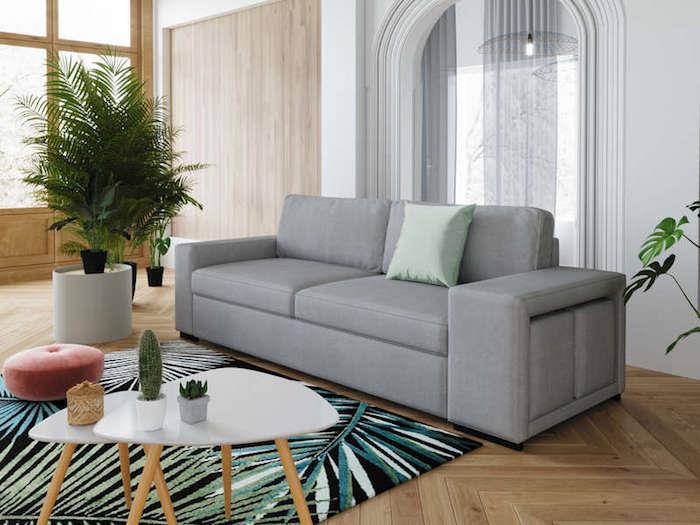 pigi sofa šviesiai pilkoje kavos staliuke baltame ir medinis kilimas mėlynos žalios ir juodos spalvos