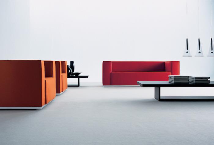 švarios modernios svetainės idėja su raudona sofa ir dizaino oranžiniais foteliais, mediniu kavos staliuku, originaliais pakabinamais žibintais