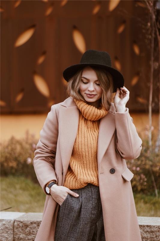 Gerai apsirengusi moteris, oranžinis megztinis su apykakle, juoda skrybėlė, morkų stiliaus kelnės, trumpas kvadrato kirpimas, šukuosenos tendencija 2020 modernus moteriškas stilius