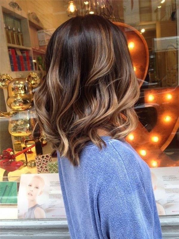 un bob con dei balayage castano chiaro e una piega alla moda con delle onde sulle punte