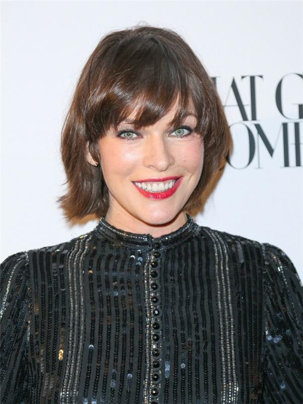 Mila Jovovich, orta uzunlukta saçaklı kare kesim, siyah gömlek, küçük düğmeler, mavi gözlü