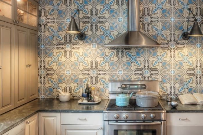 kuhinjska stena s ploščicami, belo barvano leseno kuhinjsko pohištvo s srebrnimi ročaji, kovinska kuhinjska oprema