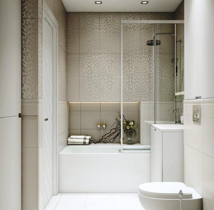 primer majhne kopalnice s kadjo v nevtralnih barvah z bež ploščicami ter kadjo in straniščno školjko v beli barvi