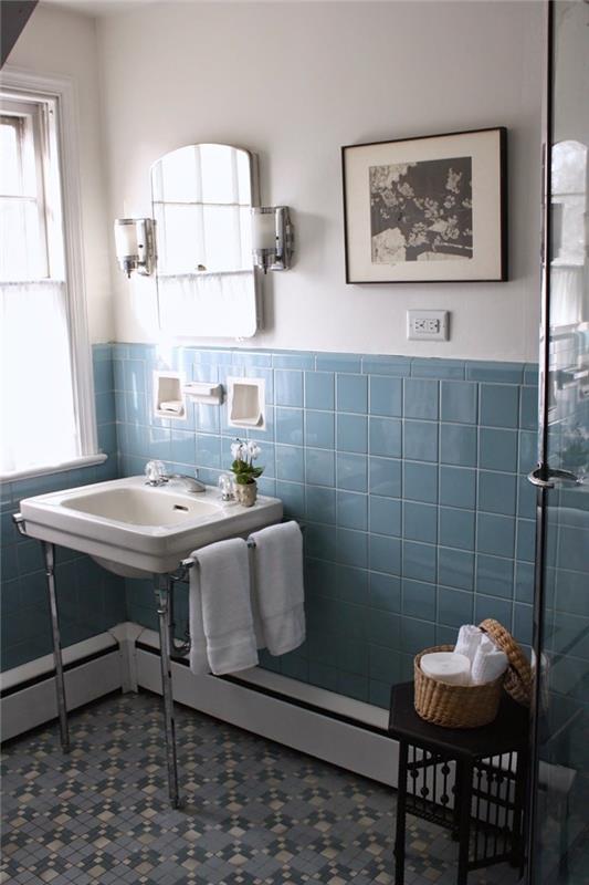 mėlyna plytelių kriauklė ant nerūdijančio plieno kojų vonios kambario dekoras nespalvotas nuotraukų rėmelis juodas išmatų austas krepšys