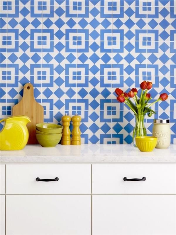 kuhinja iz cementnih ploščic v beli in modri barvi z geometrijskimi vzorci, okrasni predmeti za kuhinjo v rumeni in zeleni barvi