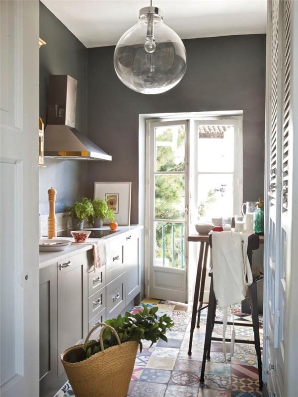 cementne ploščice na tleh v geometrijskem in večbarvnem dizajnu, kuhinja s temno sivimi stenami in svetlo sivim pohištvom