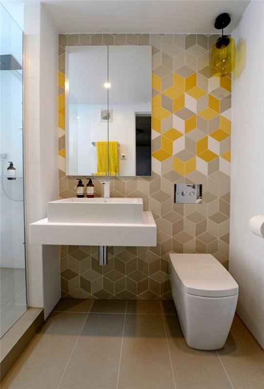 primer dekoracije majhnega prostora v kopalnici s tuš kabino, stensko oblogo iz bež in rumene ploščice