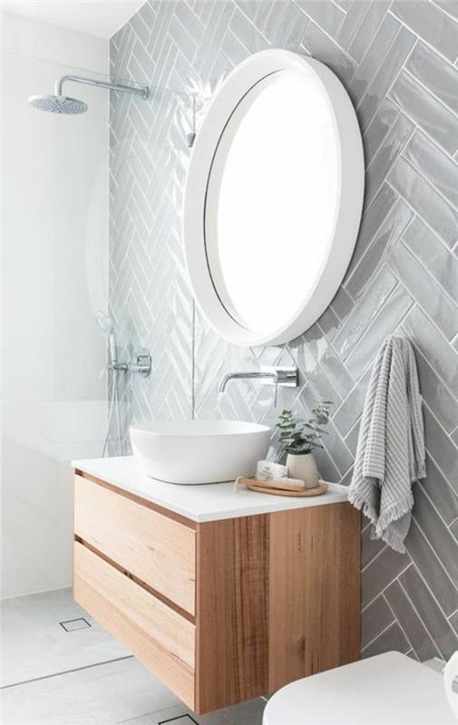 kopalnica 4m2, stene v biserno sivi barvi, okroglo ogledalo z belim okvirjem, italijanski tuš v majhnem prostoru, viseča omara v bež barvi