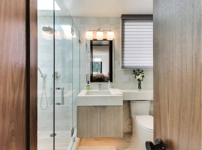 primer, kako urediti sodobno kopalnico z belimi in sivimi marmornimi ploščicami, model toaletne enote z lesenimi vrati