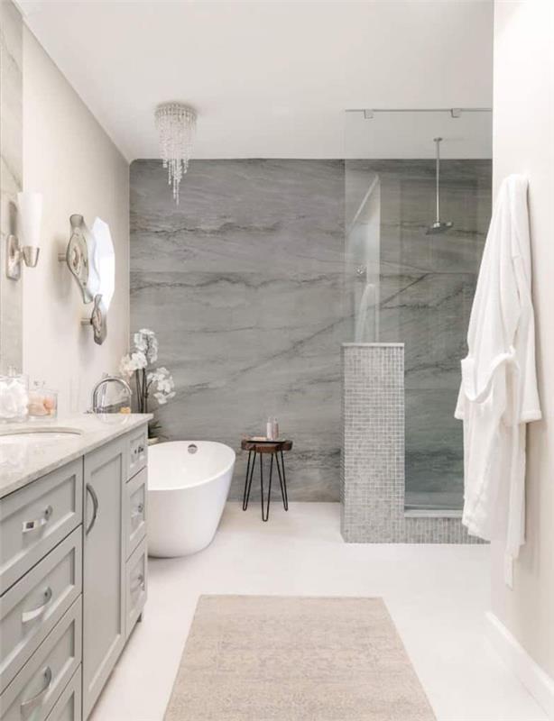 pilkos akmens vonios plytelės balta siena ir grindys pilka spintelė po kriaukle