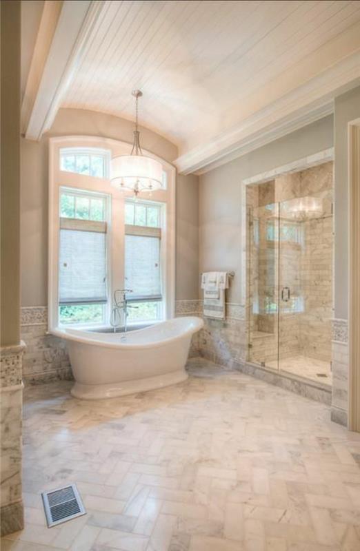 plytelėmis išklotas vonios kambarys-smėlio spalvos grindys-didelis langas ir vonia