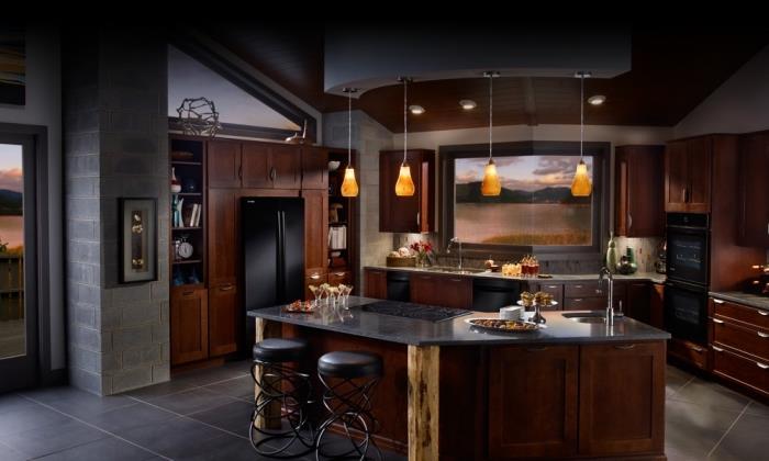 virtuvė su pilkomis sienomis su tamsiai rudos medienos spintelėmis ir juodo marmuro stalviršiu
