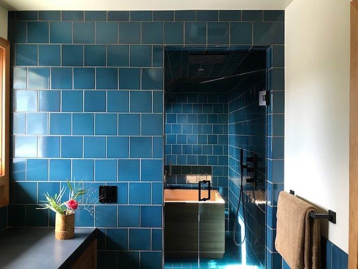 modre kopalniške ploščice s kadjo, lesena kopalniška omara s sivo delovno ploščo
