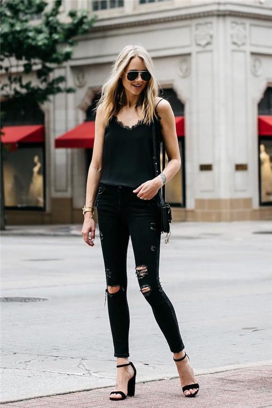 Elegantiška visiškai juodos spalvos moteriška kasdieninė apranga, suplyšę džinsiniai sandalai ir juoda palaidinė su nėrinių viršumi, prašmatni laisvalaikio moteris
