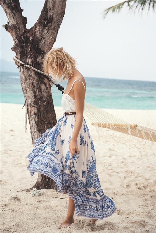 vasaros paplūdimio moterų mada su balta petnešėlių suknele su mėlynais raštais ir rudu odiniu diržu