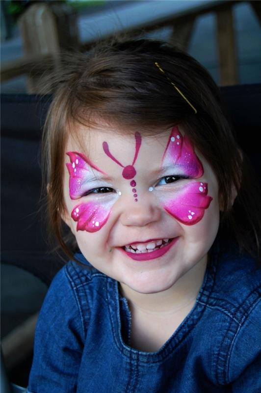 enostaven model ličenja metulja z enostavno poslikavo fuksije roza in bele barve na obrazu deklice