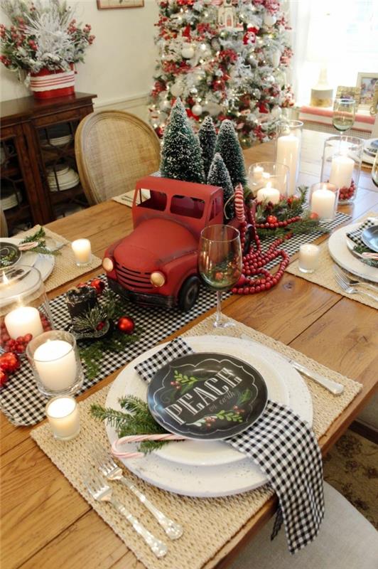 dirbtinės Kalėdų eglutės, raudonas sunkvežimio žaislas, dekoratyvinės eglutės, kvadratinės servetėlės, uogos ir raudoni rutuliai