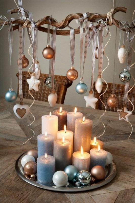 Božični DIY, božični osrednji del, ustvarjen z enajstimi velikimi in majhnimi svečami in barvitimi božičnimi kroglicami, vse postavljeno na okrogel kovinski pladenj v srebrni barvi, veja s kroglami in zvezdami, obešenimi s trakovi v ploščicah