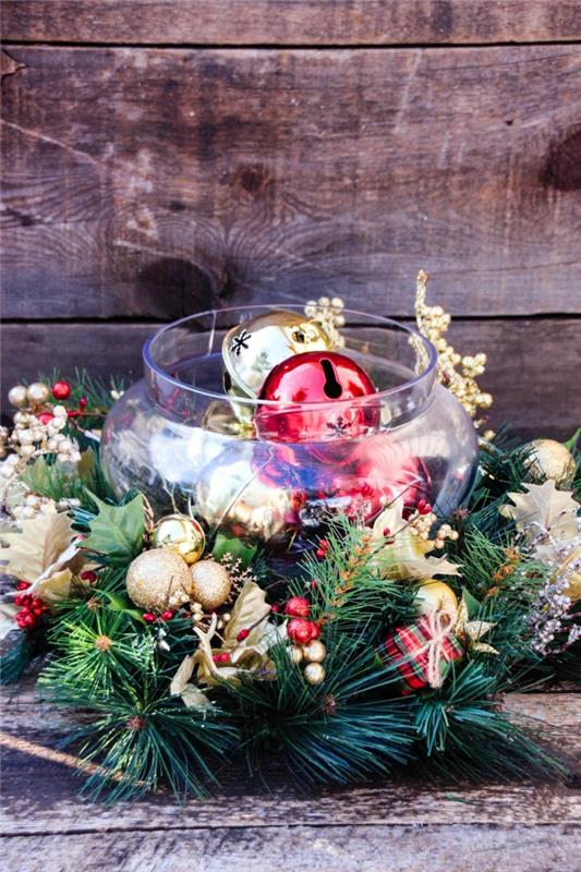 stiklinė vaza, pripildyta šventinių rutulių, auksinės spalvos kalėdiniai rutuliai, pušies šakelės, lentos