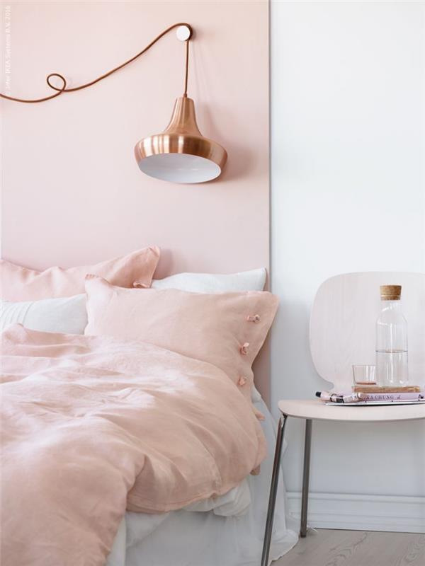 merginos miegamojo išdėstymas su baltomis sienomis su rožine miltelių keptuvė, žema lova su pramonine lempa, pagaminta iš vario