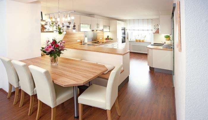 sodoben dizajn v kuhinji, odprti za dobro opremljeno jedilnico z rjavim lesenim podom in belim stropom