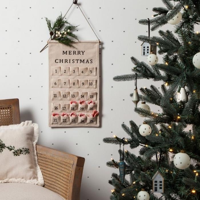 Beyaz figürinler ve hafif çelenk ile minimalist tarzda dekore edilmiş Noel ağacı modeli, beyaz İskandinav tarzı bir odada koza atmosferi