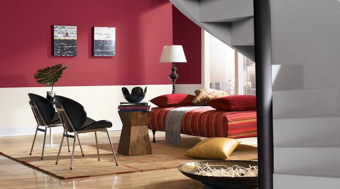 oturma odası dekor fikri, bordo kırmızı duvar paneli, renkli çizgili kırmızı şezlong, bej halı, siyah sandalyeler, rustik ahşap sehpa