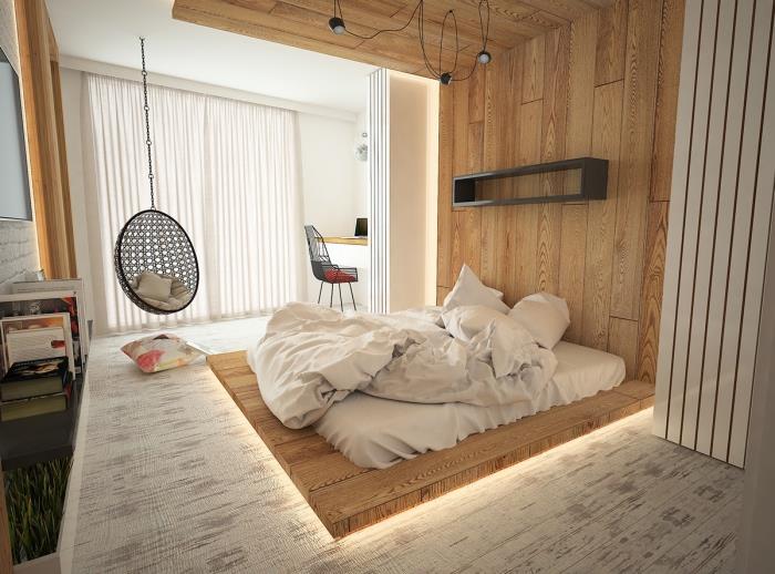 Bir koza atmosferi için alçak yatak ve asma sandalye ile İskandinav tarzında eksiksiz yetişkin yatak odası
