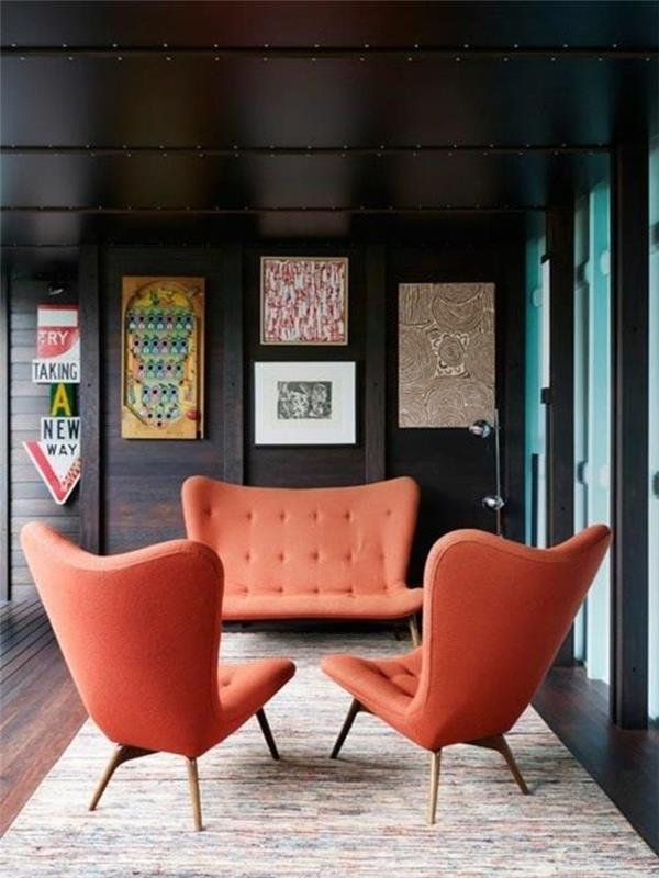 stoli in kavč v barvi marelic, pravokotna preproga, rjave stene, tla in strop