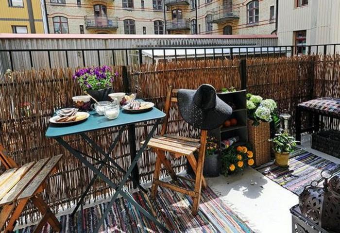 pavyzdys mažos terasos su augaliniu vėjeliu, sulankstomos medinės kėdės, metalinis sulankstomas stalas, keli žydintys augalai