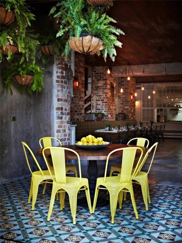 geltonos geležies kėdės-spalvos-plokštės-grindys-plytų siena-tamsiai-medžio-medinis-stalas