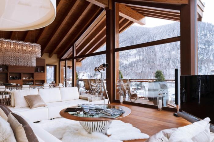 brunarica v gorah čudovit snežni pogled okrogla miza kosmat preproga beli kavč kokoniranje deko prijetna dnevna soba udoben kavč